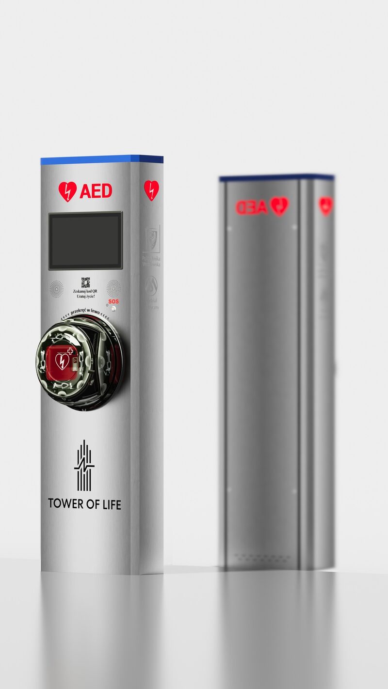 Tower of Life w przestrzeni miejskiej — hermetyczna kapsuła AED, ekran i interkom SOS na tle drugiej wieży.